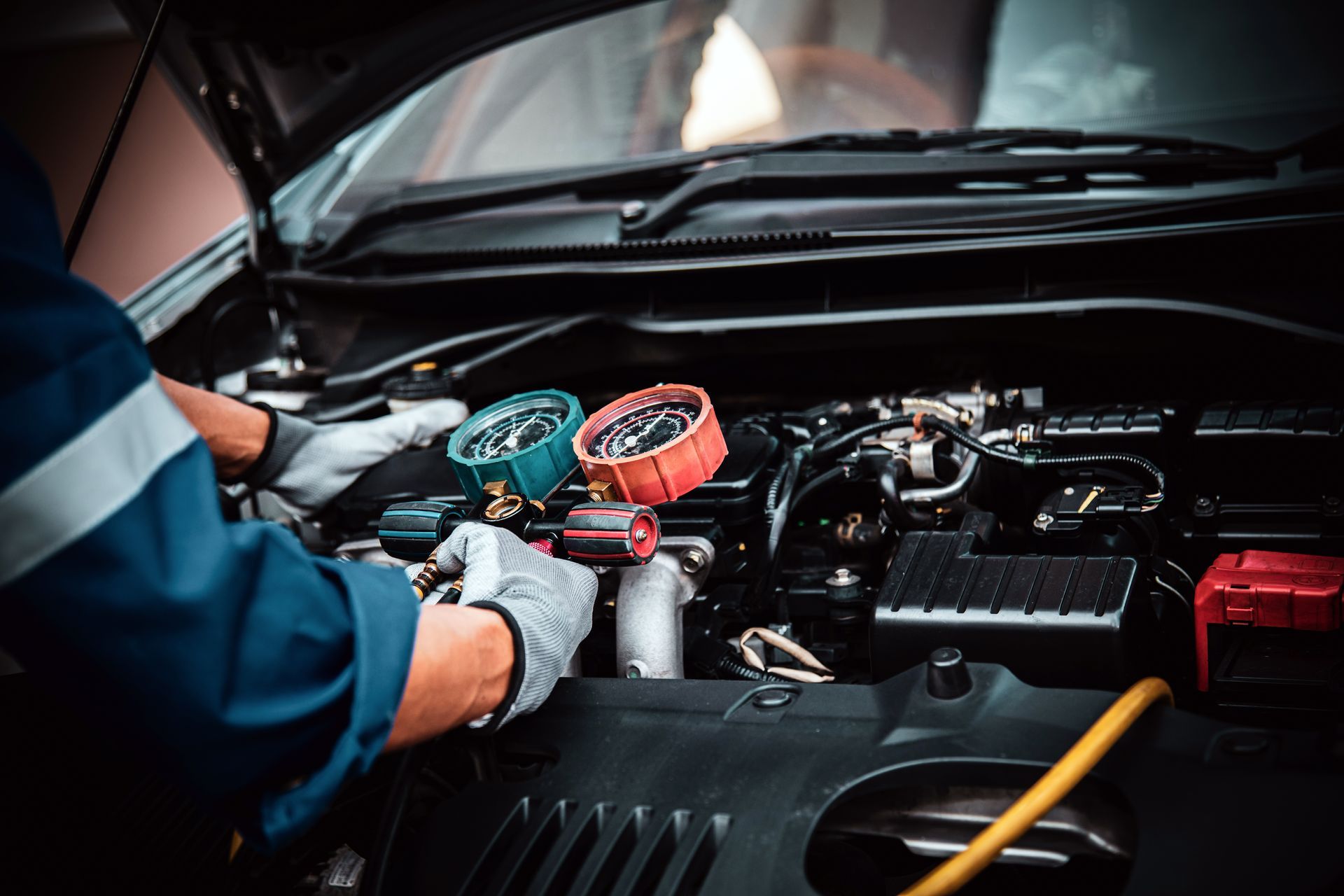 A mechanic is working on the engine of a car.