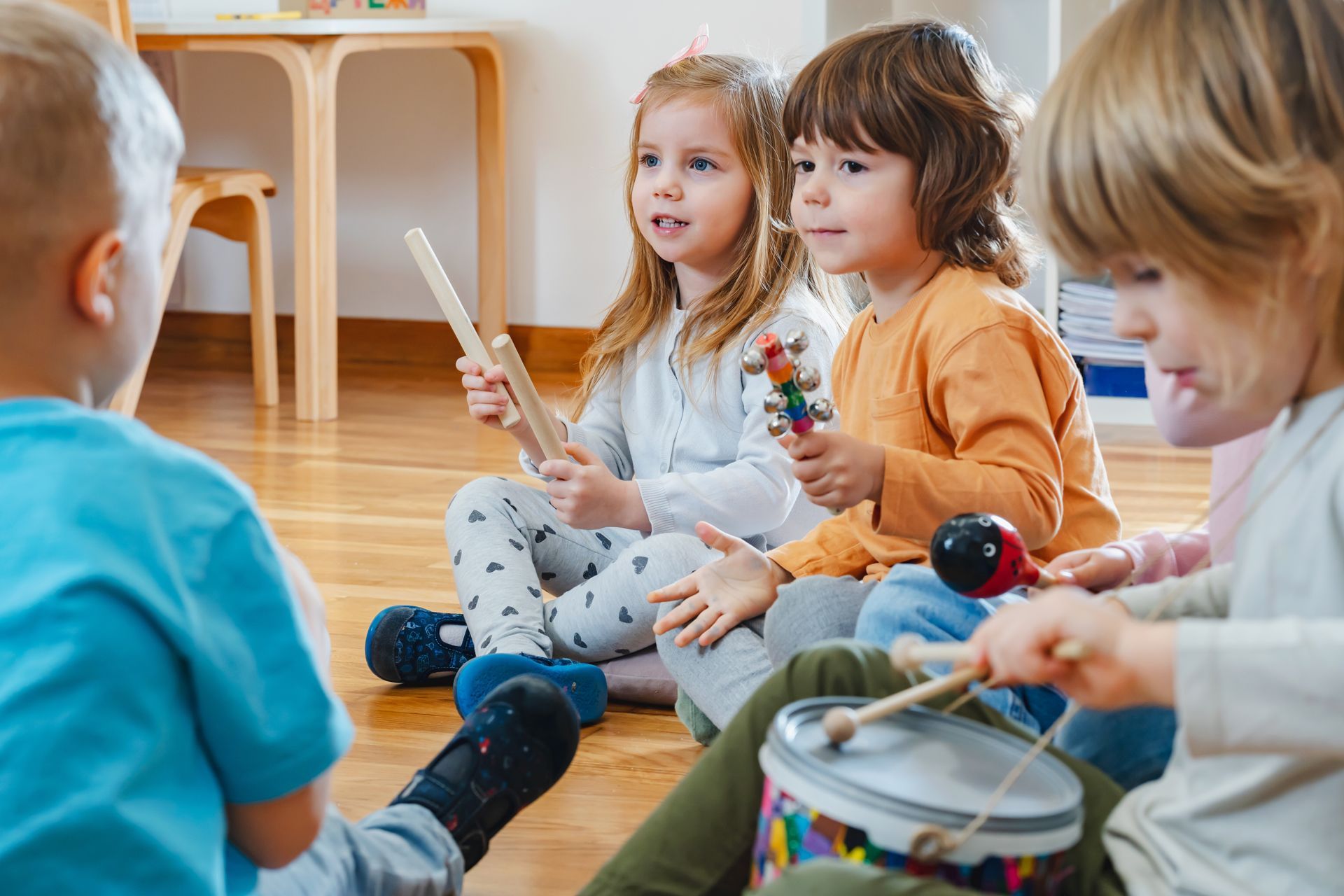Group of Children Are Sitting on the Floor Playing Musical Instruments.
