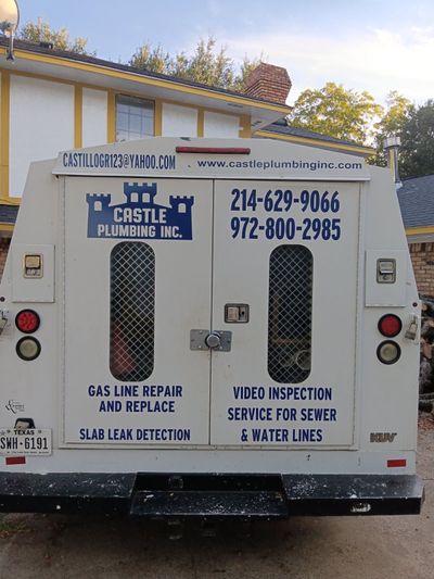 Back of a white Castle Plumbing service truck with text: company name, phone numbers, and service descriptions.