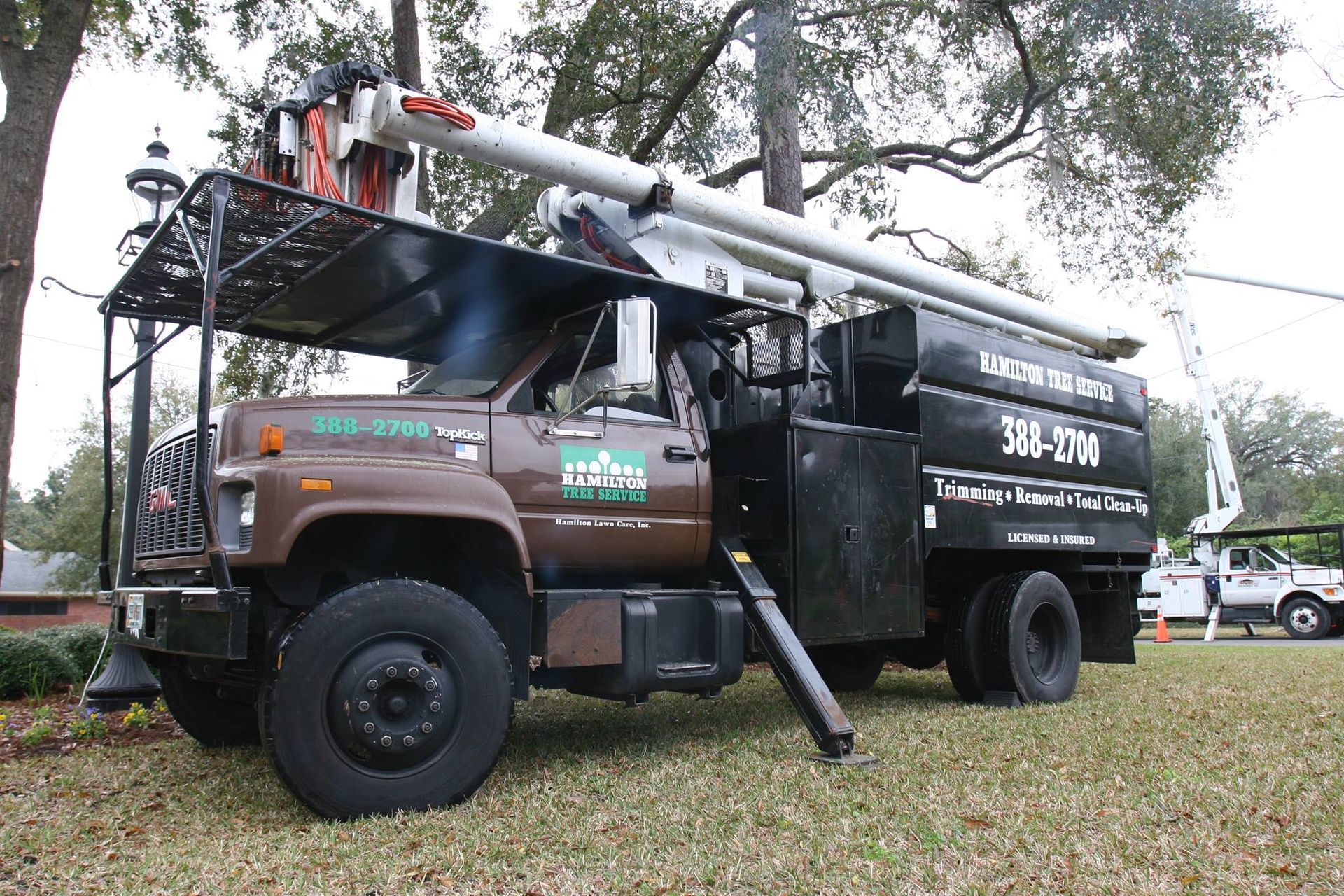 A truck with a crane on top of it is parked in the grass.