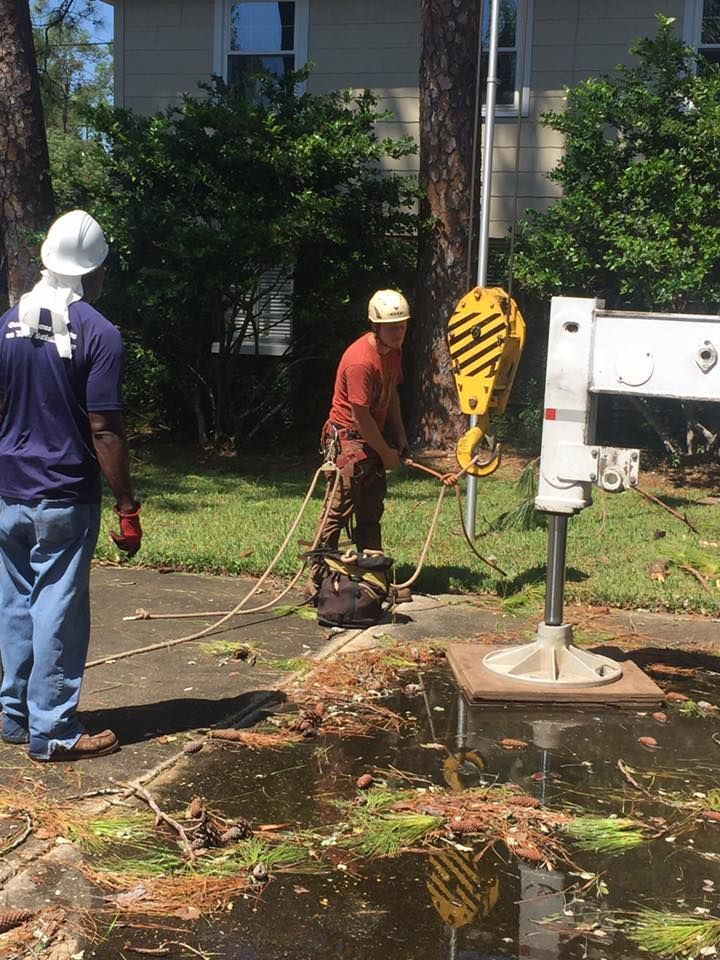 Two men are working on a crane in a yard