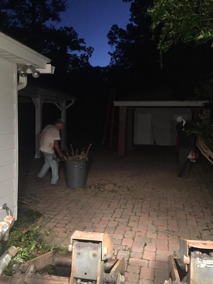 A group of people are working on a brick driveway at night