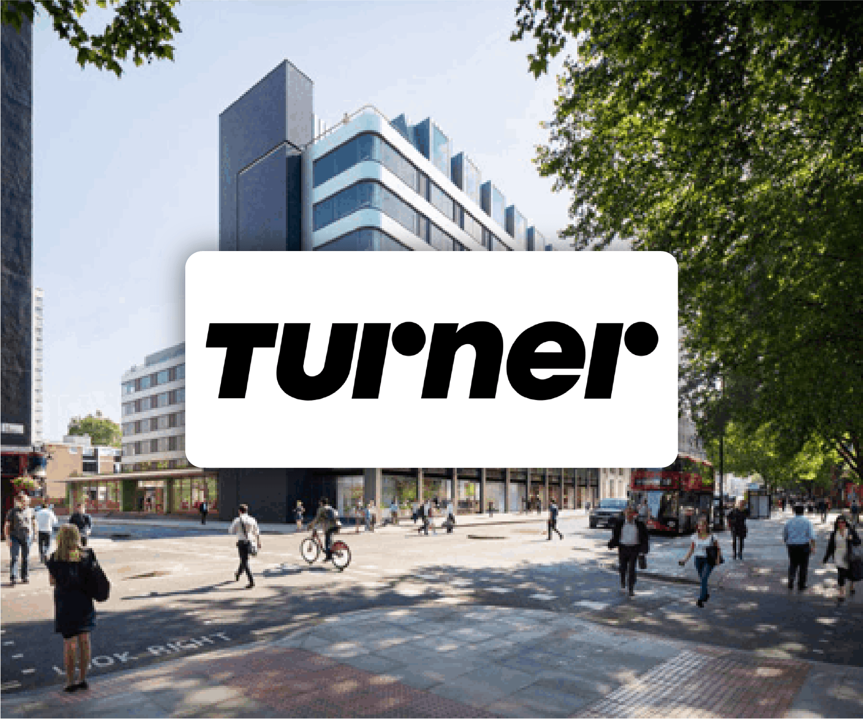 A group of people are walking down a street in front of a large building.