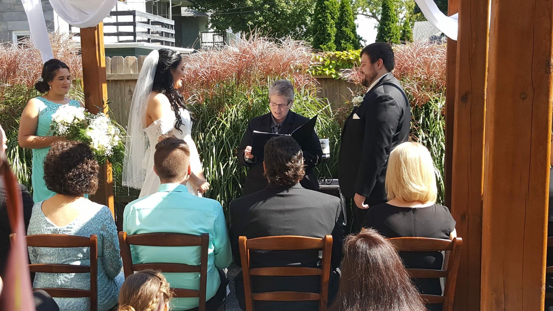 A bride and groom are getting married in front of a crowd of people.