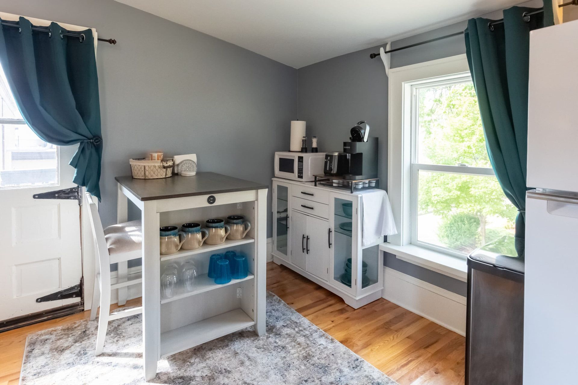 A kitchen with a table and chairs and a refrigerator.