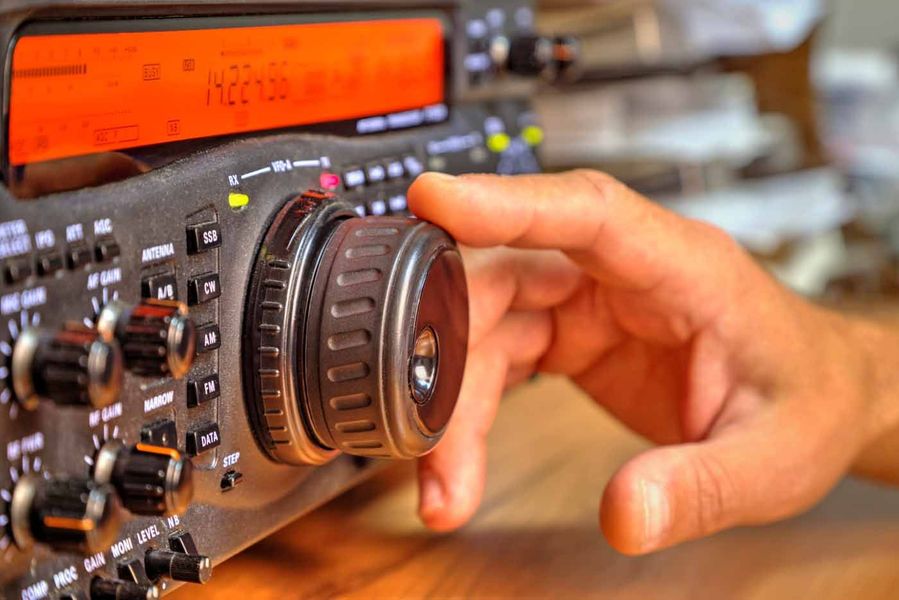 A person is adjusting a knob on a radio.