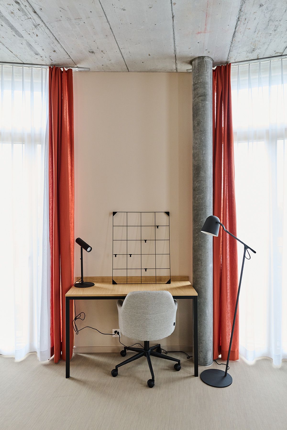 Im Zimmer gibt es einen Schreibtisch mit Stuhl und Lampe.