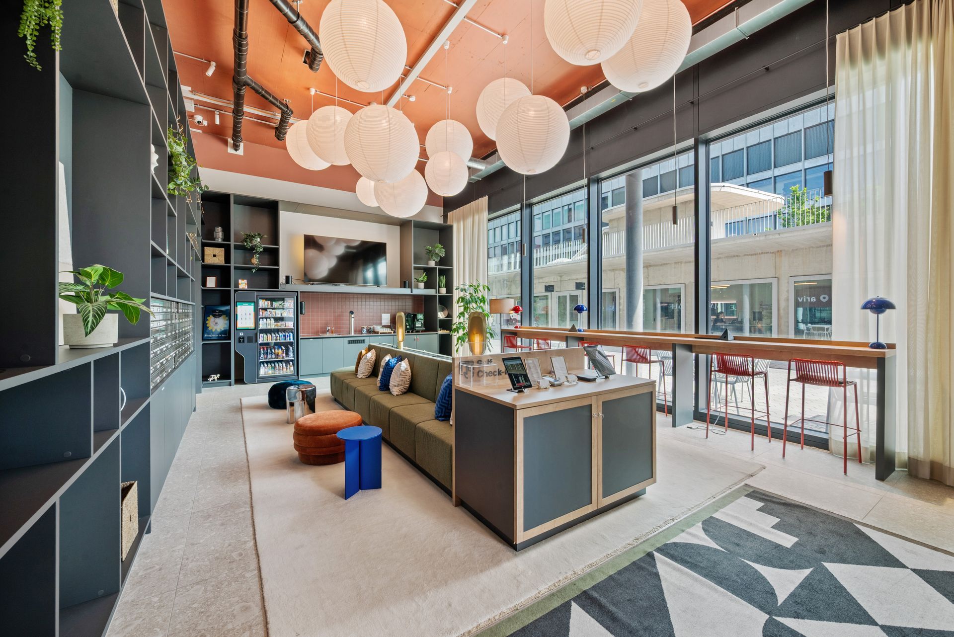 A living room with a couch , table , and lots of windows.