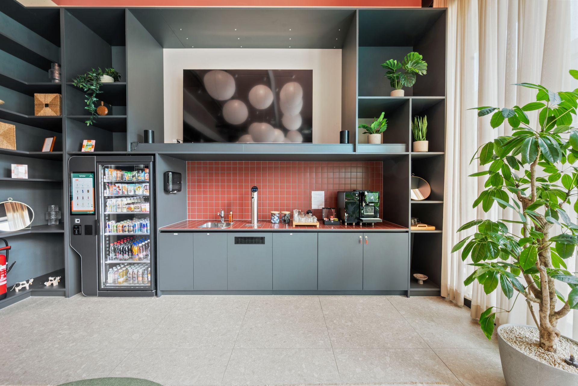 A kitchen with a refrigerator and a tv on the wall.