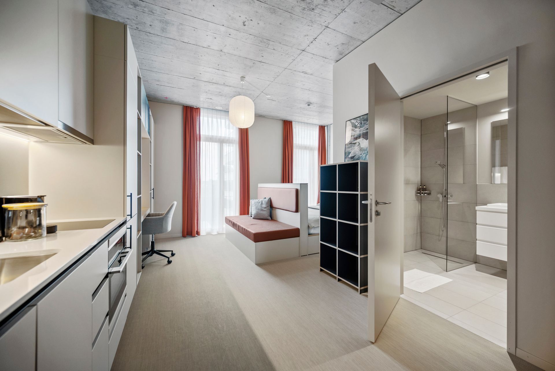 Künstlerische Darstellung eines Studio-Apartments mit Küche, Schlafzimmer und Badezimmer.