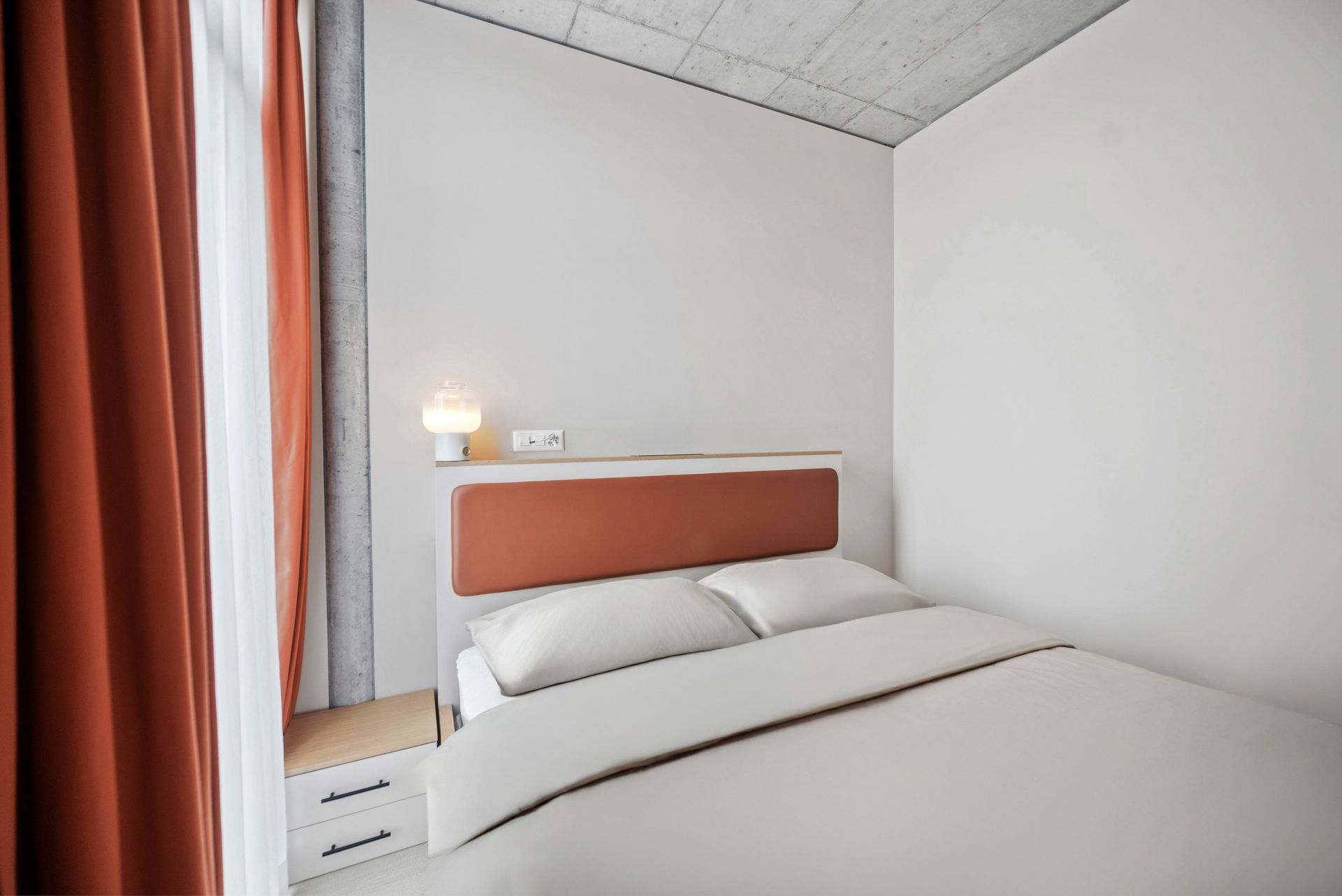 A bedroom with a bed and a window.