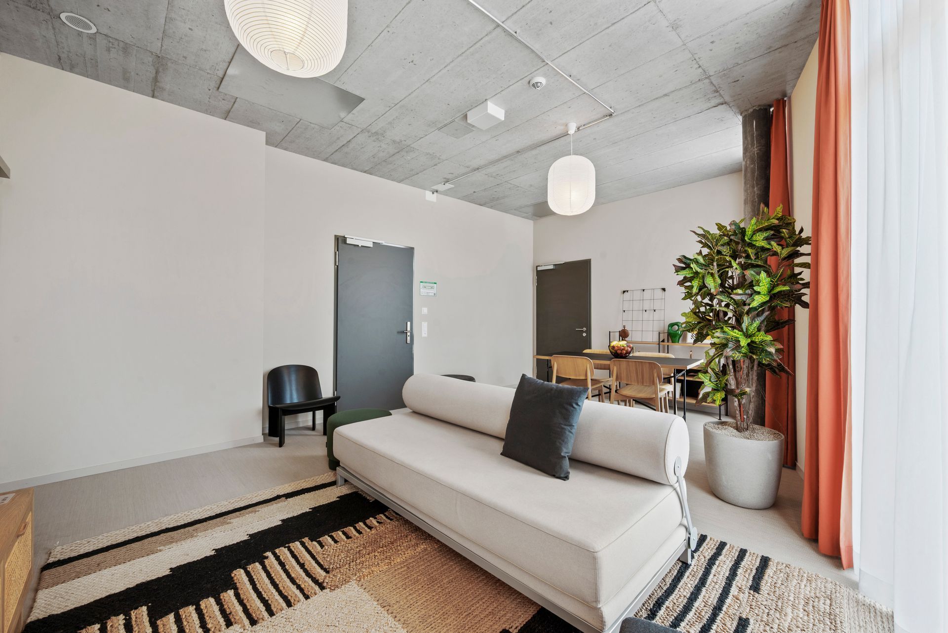 Ein Wohnzimmer mit Sofa, Sessel und Teppich.