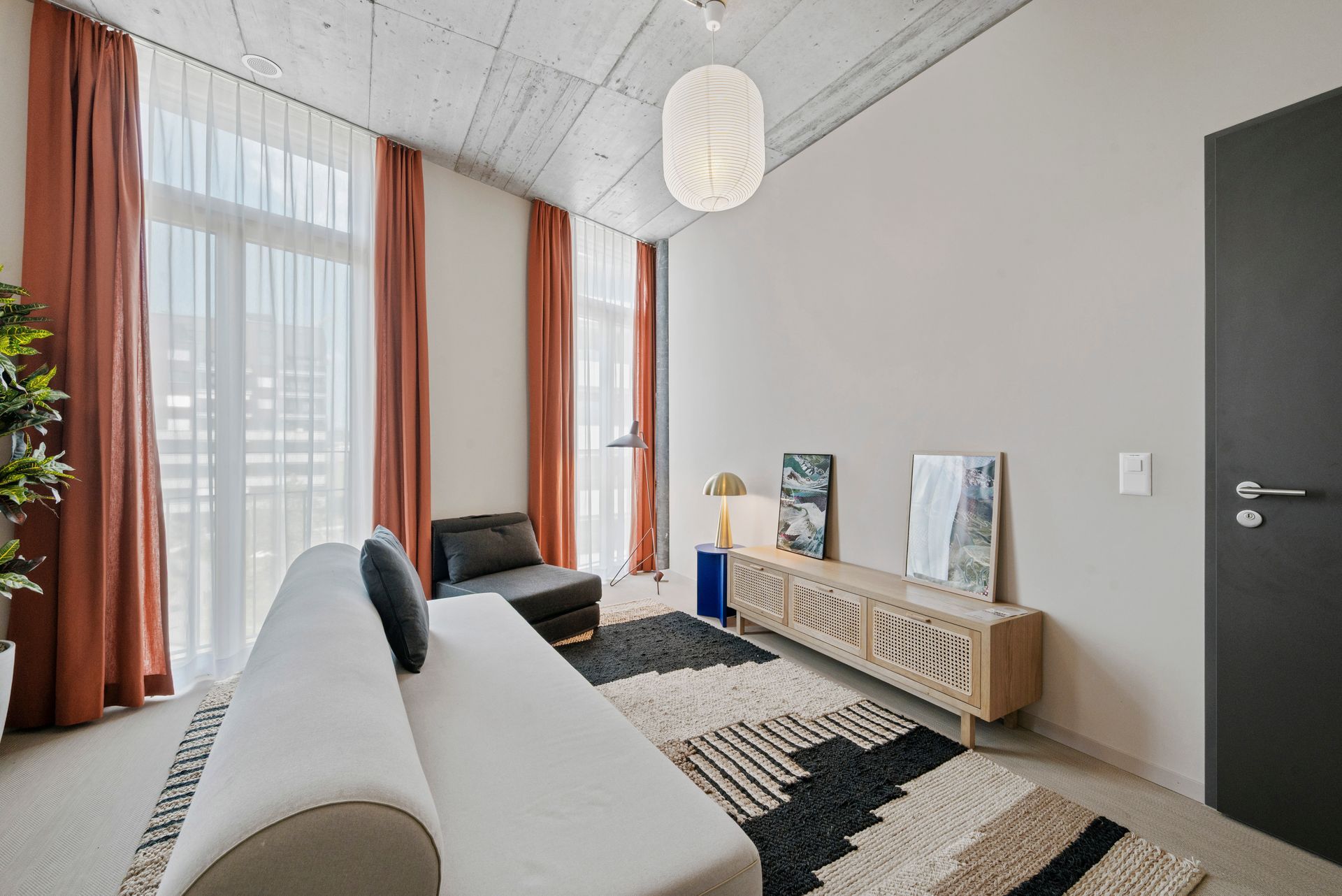 Ein Wohnzimmer mit Sofa, Sessel und Teppich.