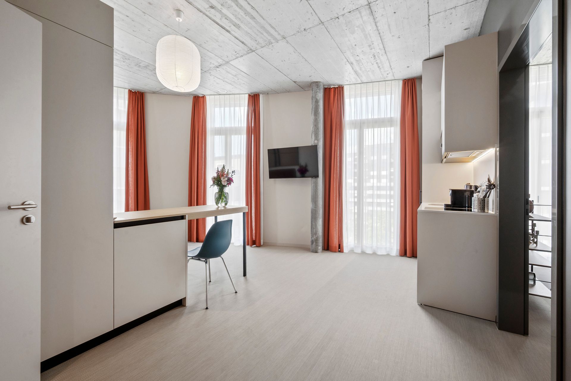 Ein Wohnzimmer mit Tisch, Stühlen und Fernseher.