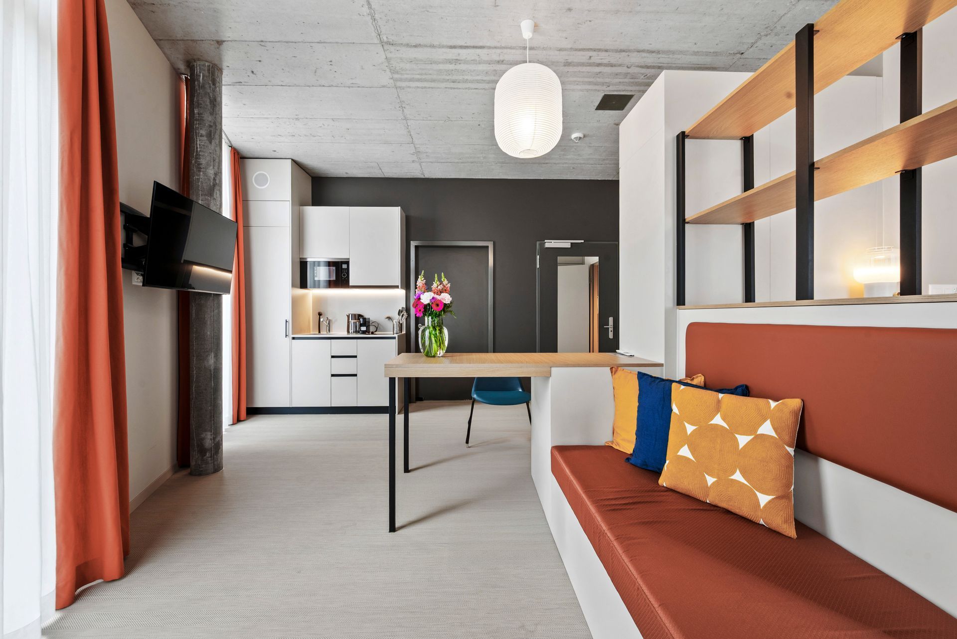 Ein Wohnzimmer mit Couch, Tisch und Fernseher.