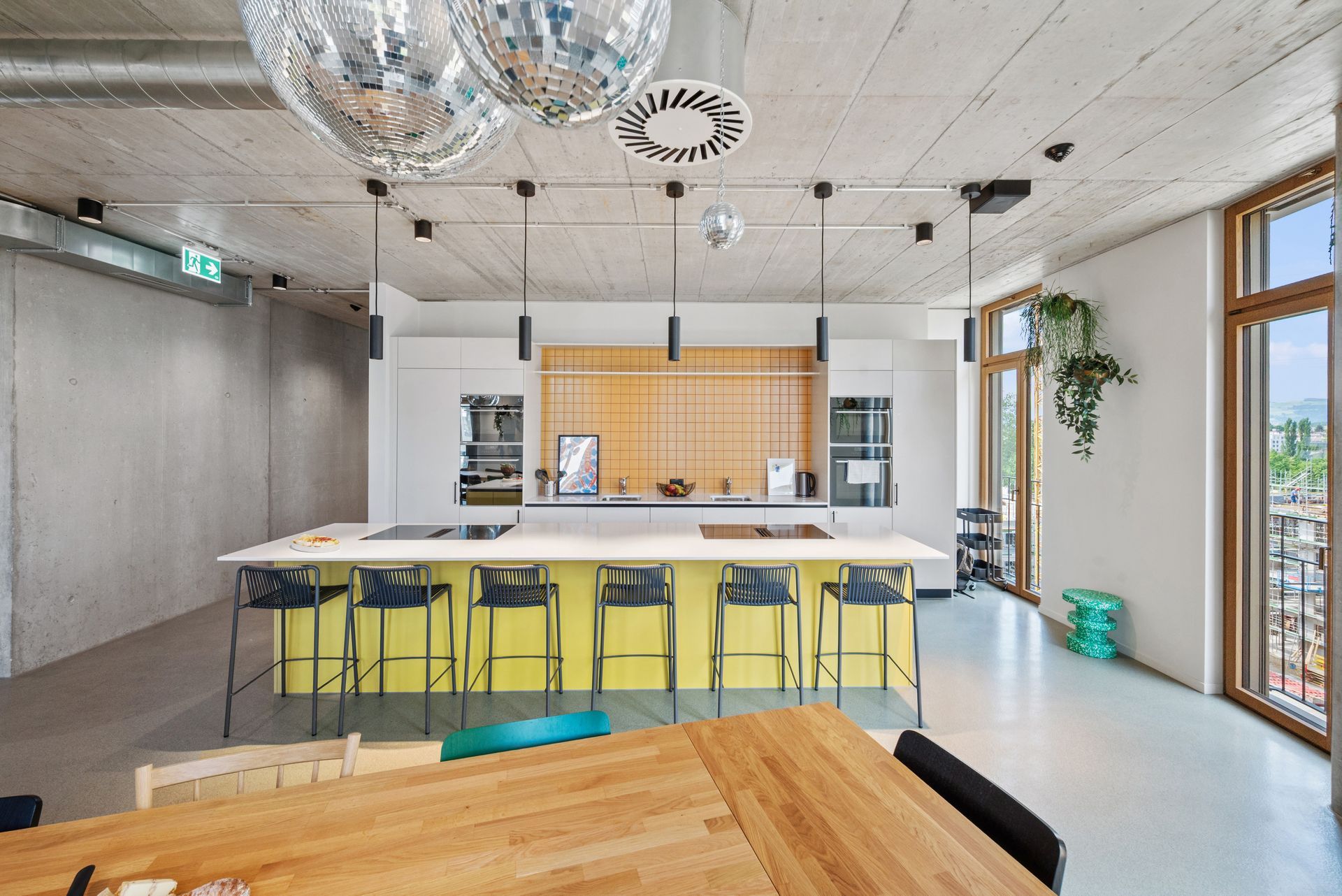 A large room with a wooden table and stools in it.