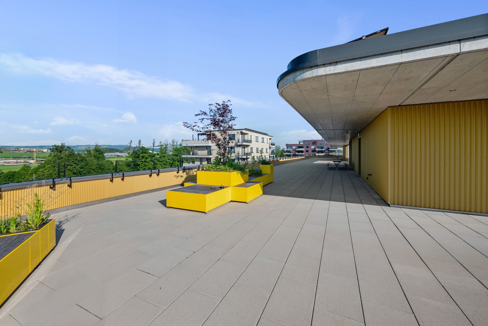 A rooftop deck with yellow planters on it