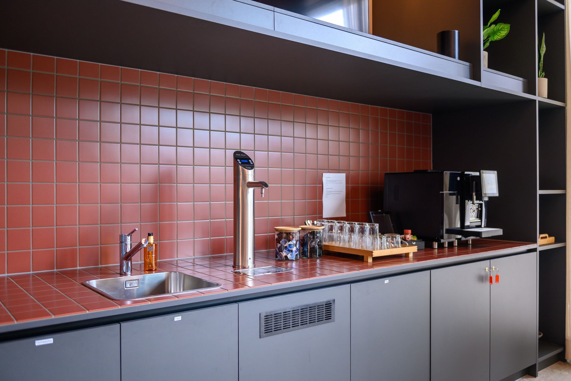 A kitchen with a sink and a coffee maker