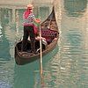 Ein Mann fährt mit einer Gondel auf einem Fluss.