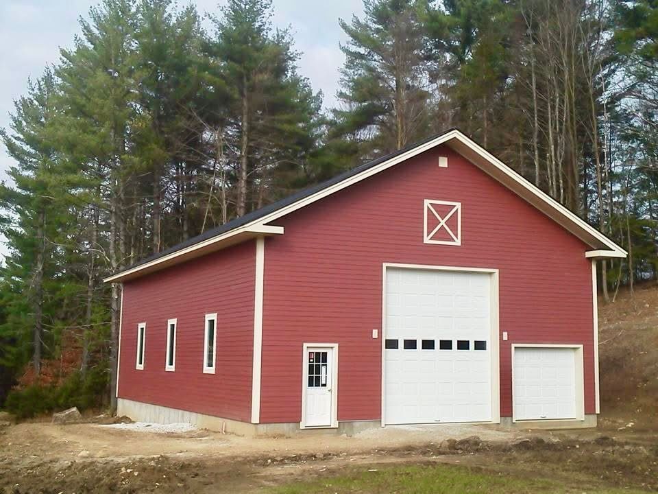 A red barn with white doors and a white x on the top