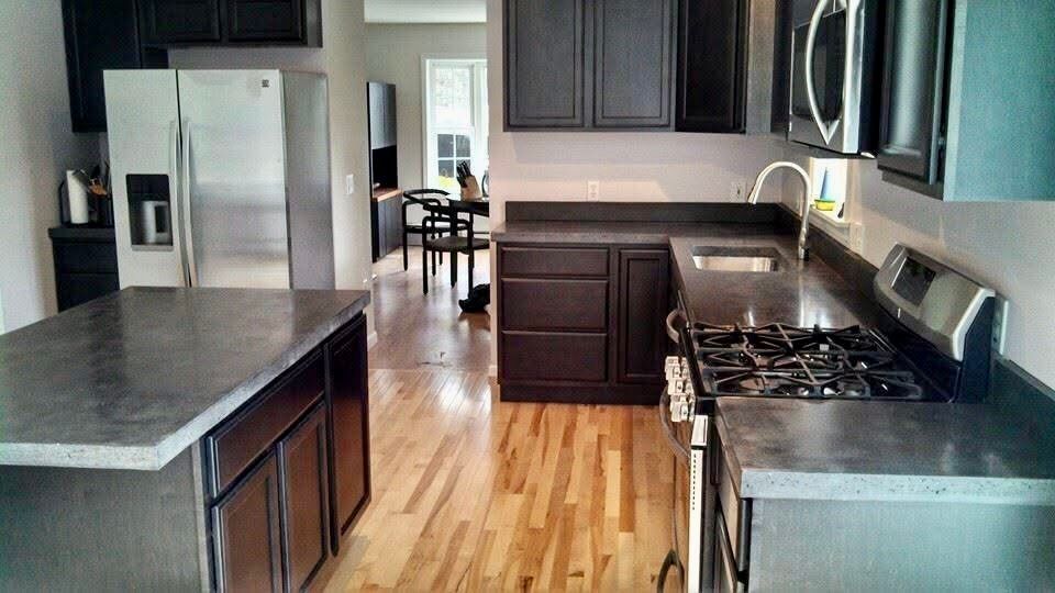 A kitchen with black cabinets and stainless steel appliances