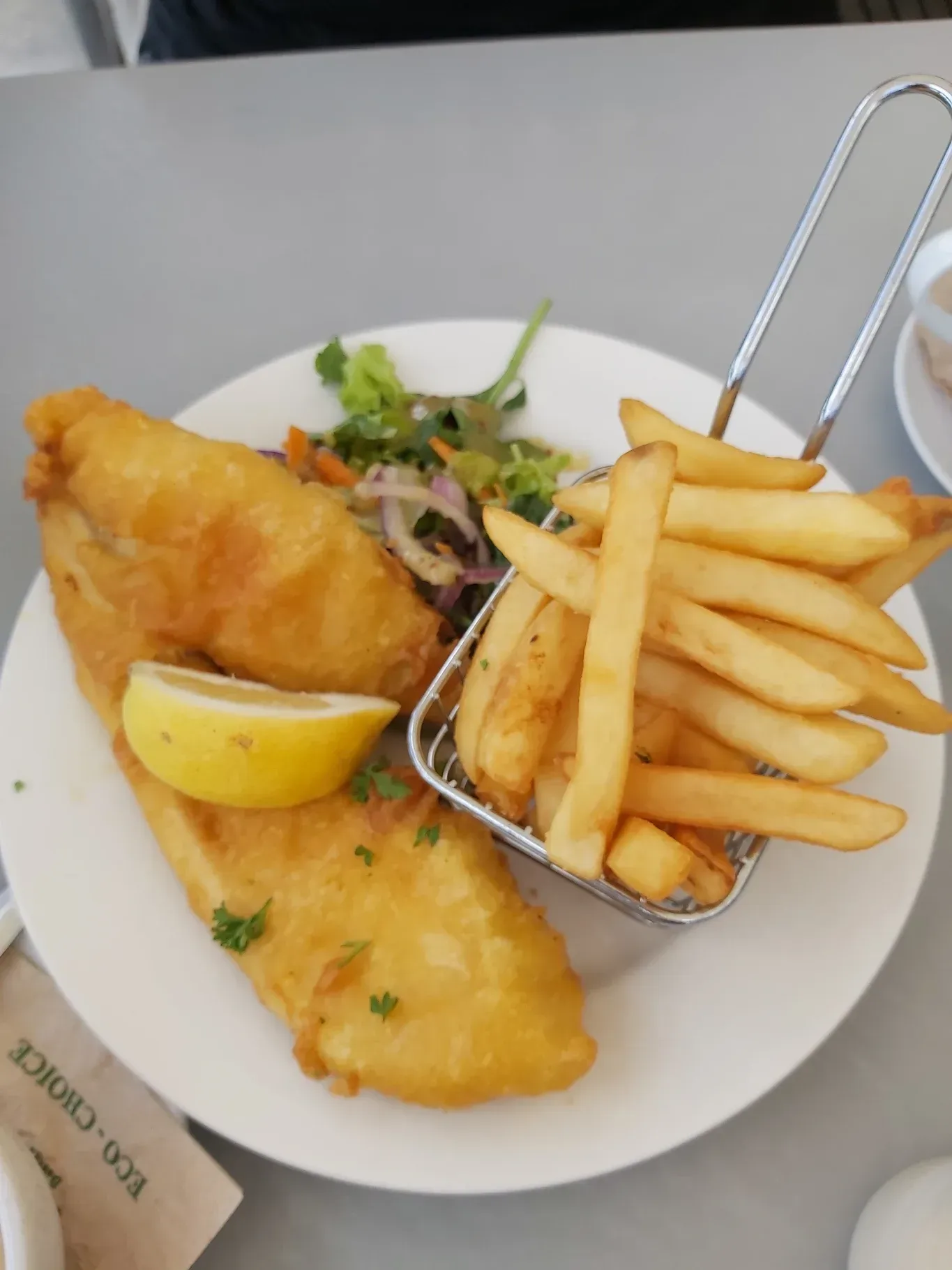 A white plate topped with fish and french fries