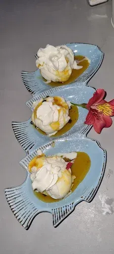 Three fish shaped plates with food on them on a table.