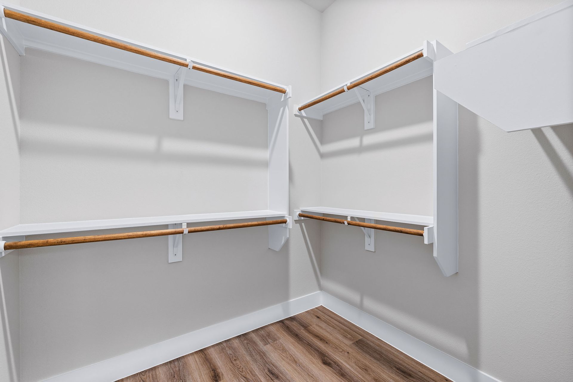 An empty walk-in closet with wooden floors and white shelves at The Wyatt, offers brand-new apartments in North Austin, TX.
