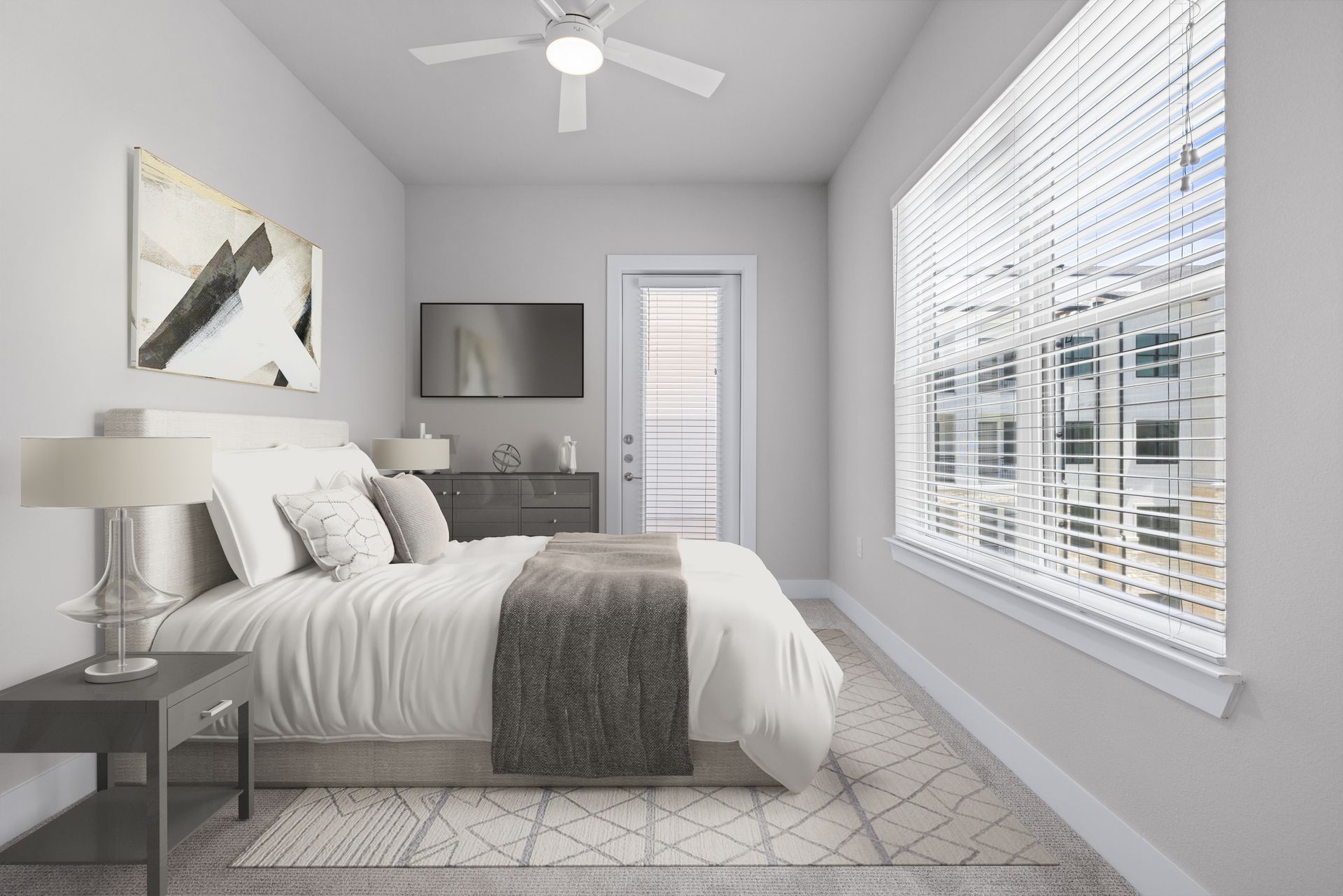A modern apartment bedroom with a bed, ceiling fan, television, and a large window at The Wyatt, offers pet-friendly apartments in Pearson Ranch Austin, TX.