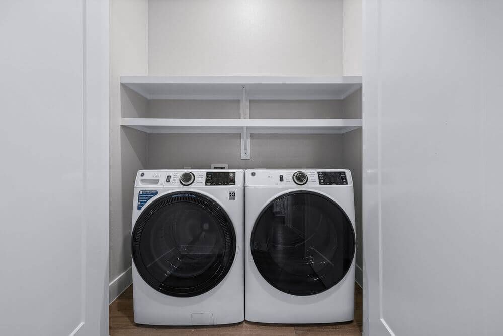 A laundry room with a washer and dryer in it at The Wyatt, offers luxury apartments in North Austin, TX.