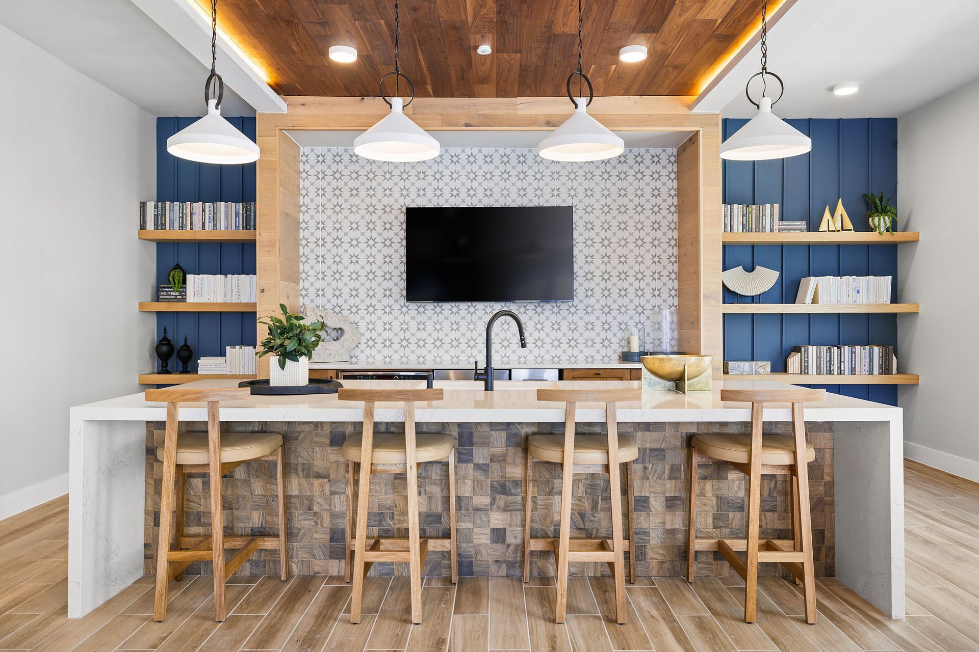 Apartment community kitchen with a large island, stools, and a flat-screen tv at The Wyatt, offers luxury apartments in North Austin, TX.
