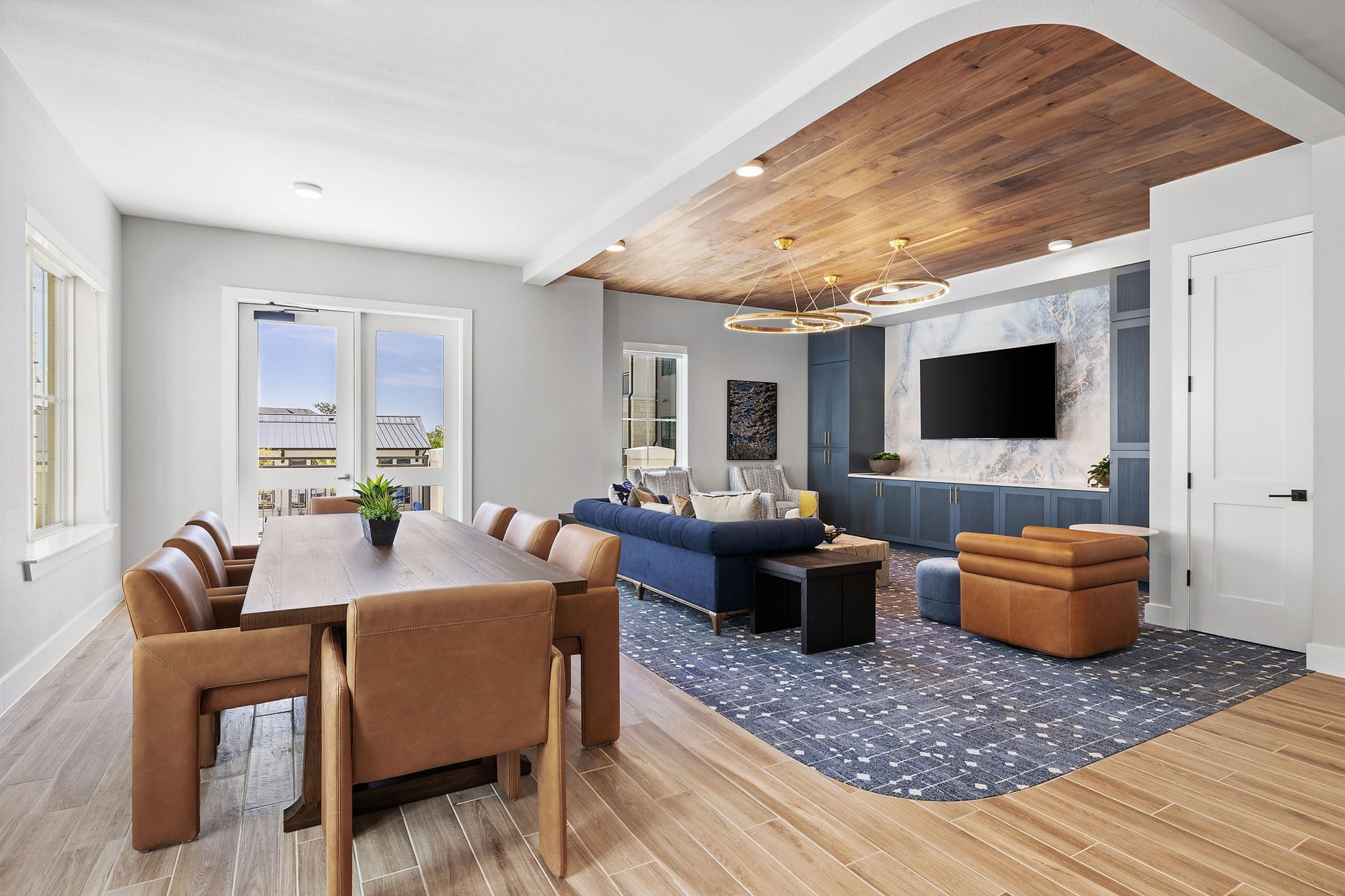 The Wyatt clubhouse with a dining table, chairs, a couch, and a television, offers apartments in North Austin, TX.
