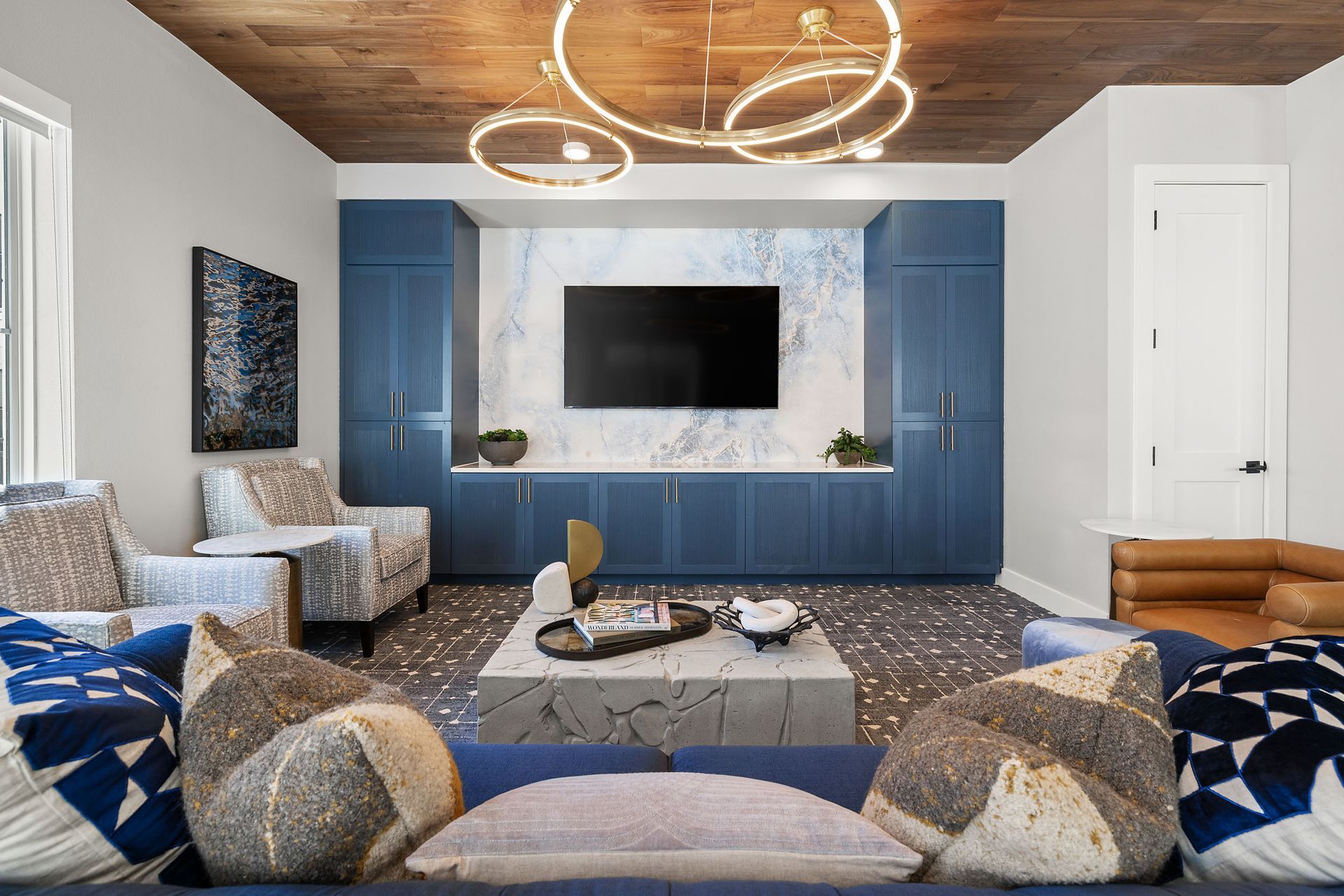 Apartment media room with a couch, chairs, and a flat-screen TV at The Wyatt, offers luxury apartments in Pearson ranch Austin, TX..