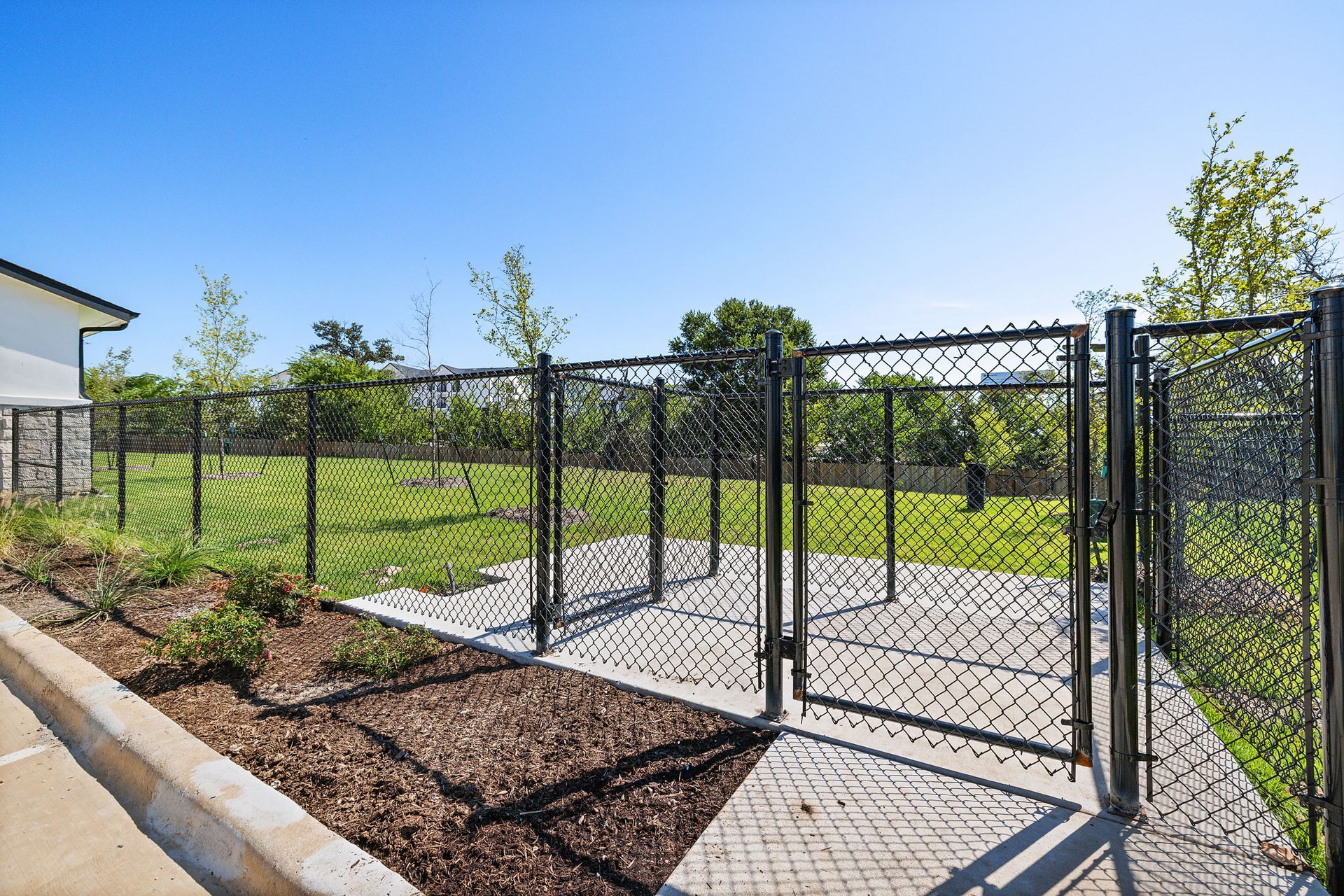A chain link fence surrounds a lush green bark park at The Wyatt, offers luxury apartments in North Austin, TX.
