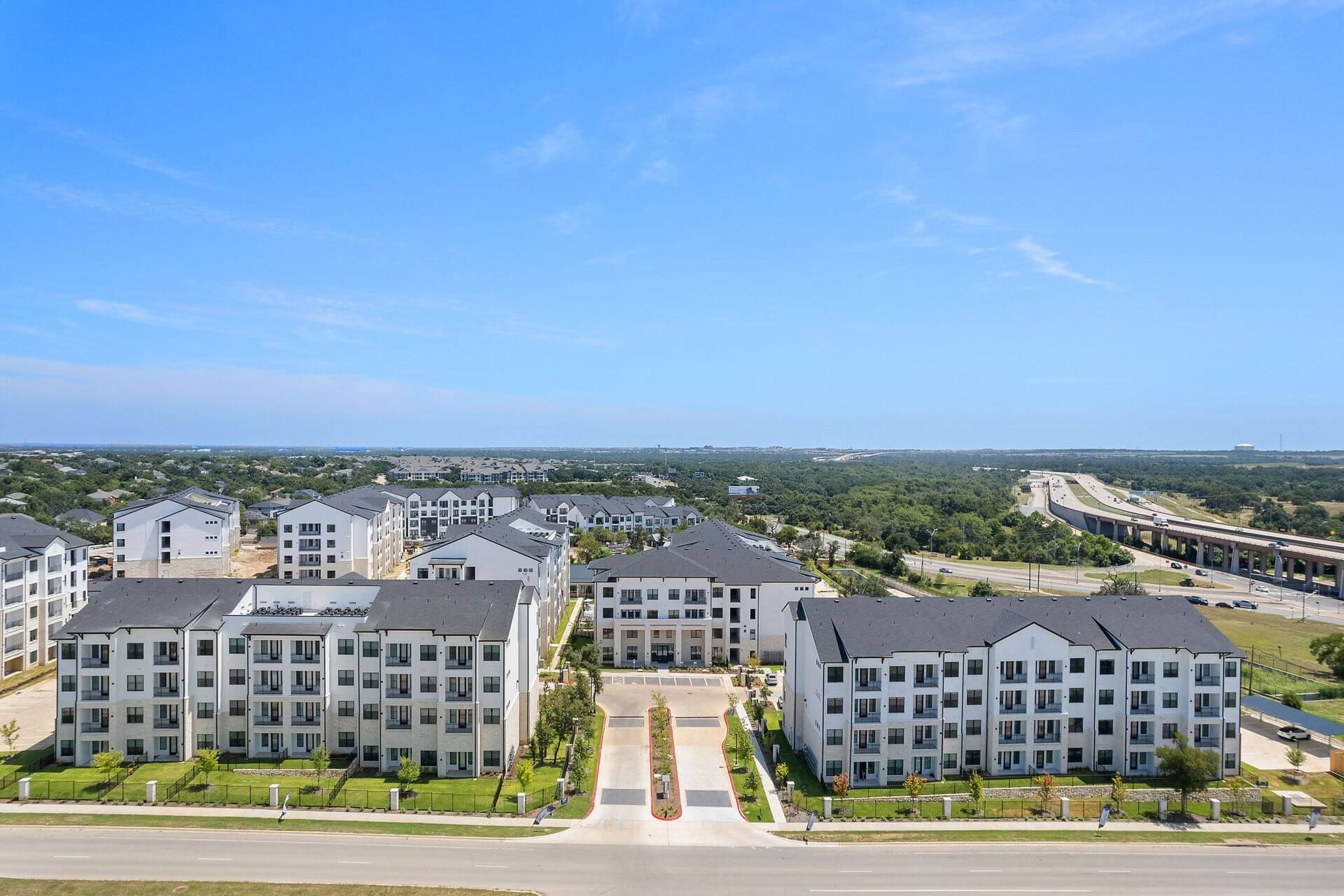 An aerial view of a large apartment complex with lots of buildings at The Wyatt, offers luxury apartments in North Austin, TX.