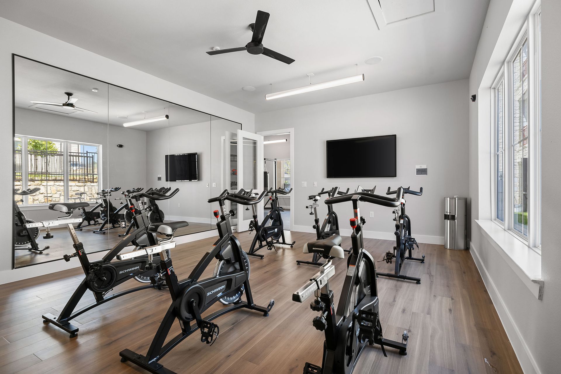 A gym with a lot of exercise bikes and a large mirror at The Wyatt, offers brand new apartments in North Austin, TX.