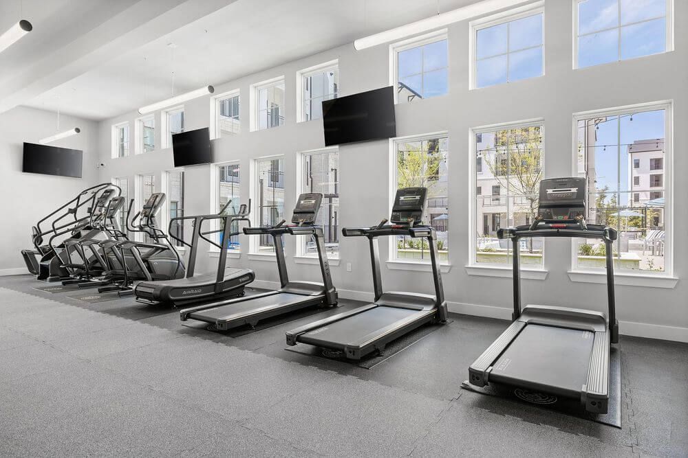 A gym with a lot of treadmills and a lot of windows at The Wyatt, offers luxury apartments in Austin, TX.