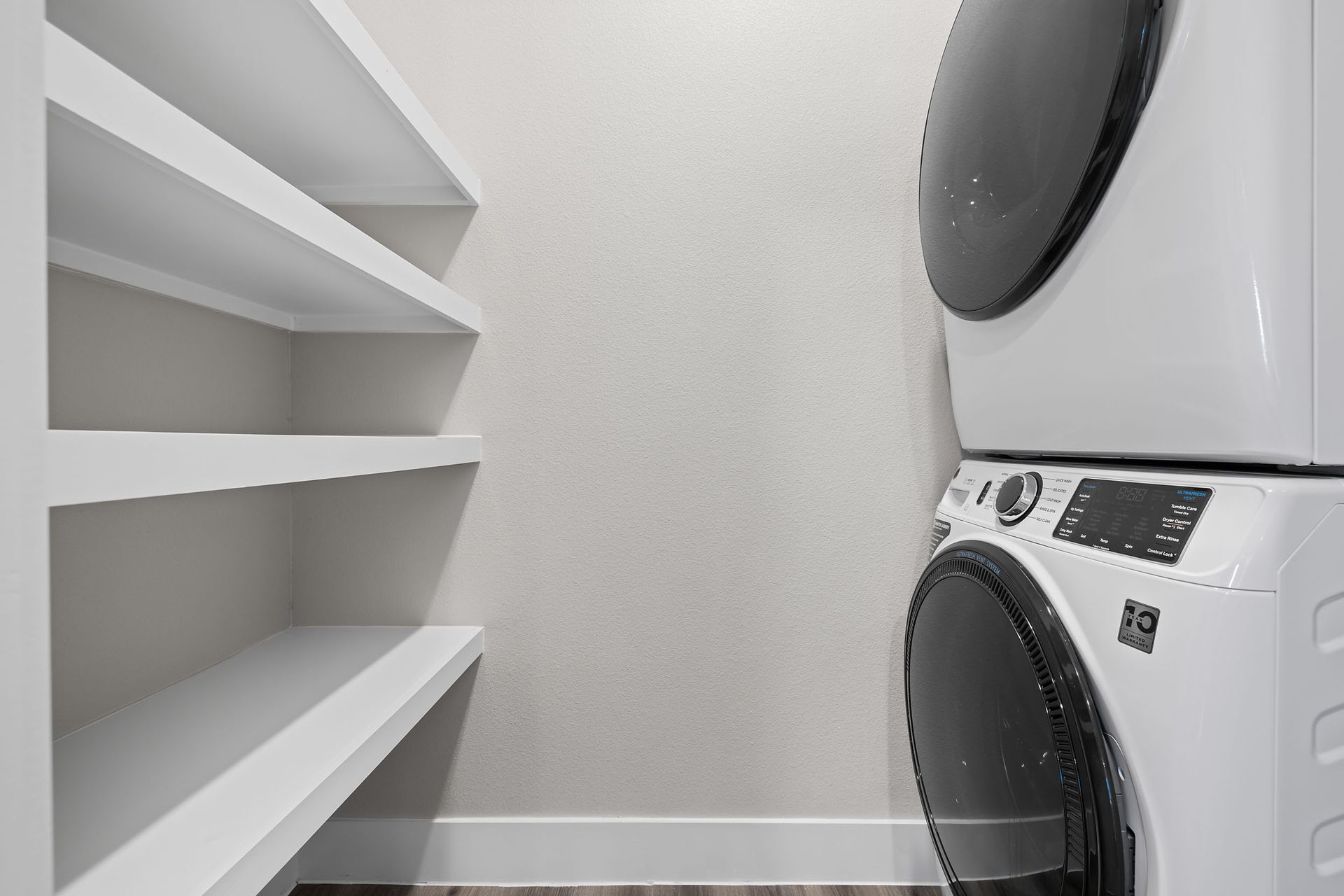 A washer and dryer are stacked on top of each other in a laundry room at The Wyatt, offers brand new apartments in North Austin, TX.