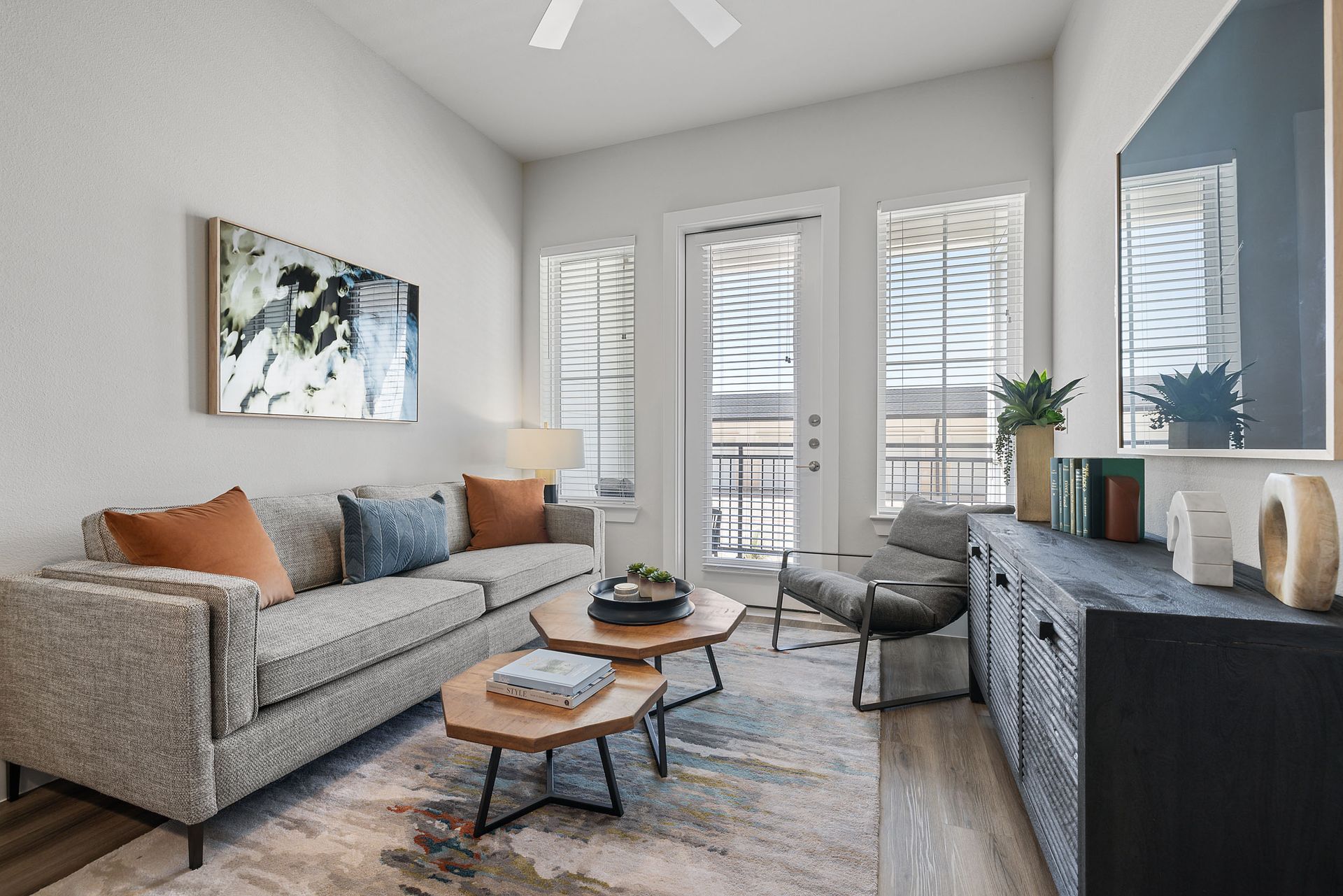 A living room with a couch, two coffee tables, oversized window, and a flat screen tv at The Wyatt, offers luxury apartments in North Austin, TX.
