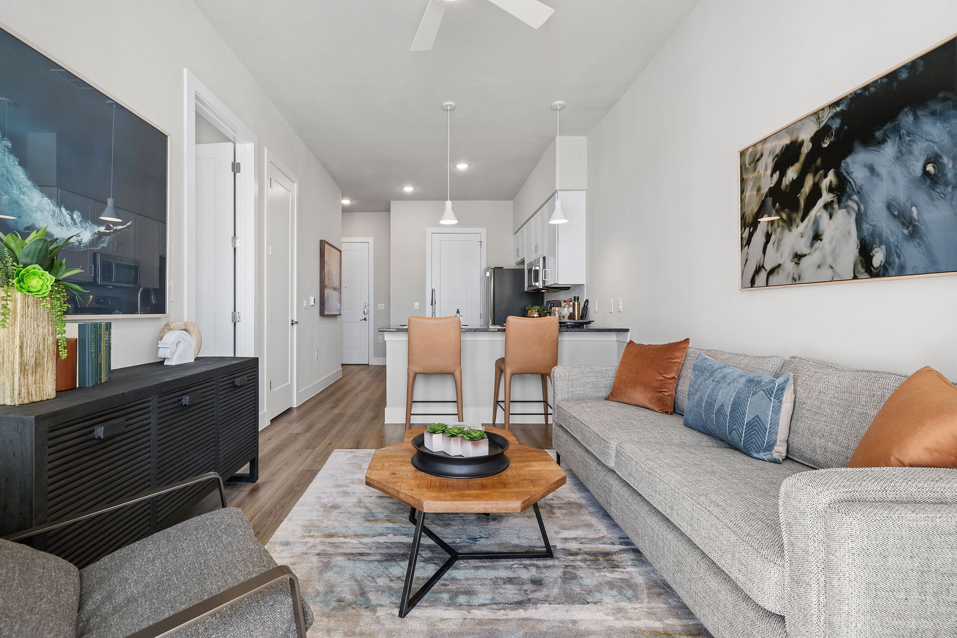 A living room with a couch, chair, coffee table, and ceiling fan at The Wyatt, offers luxury apartments in North Austin, TX.