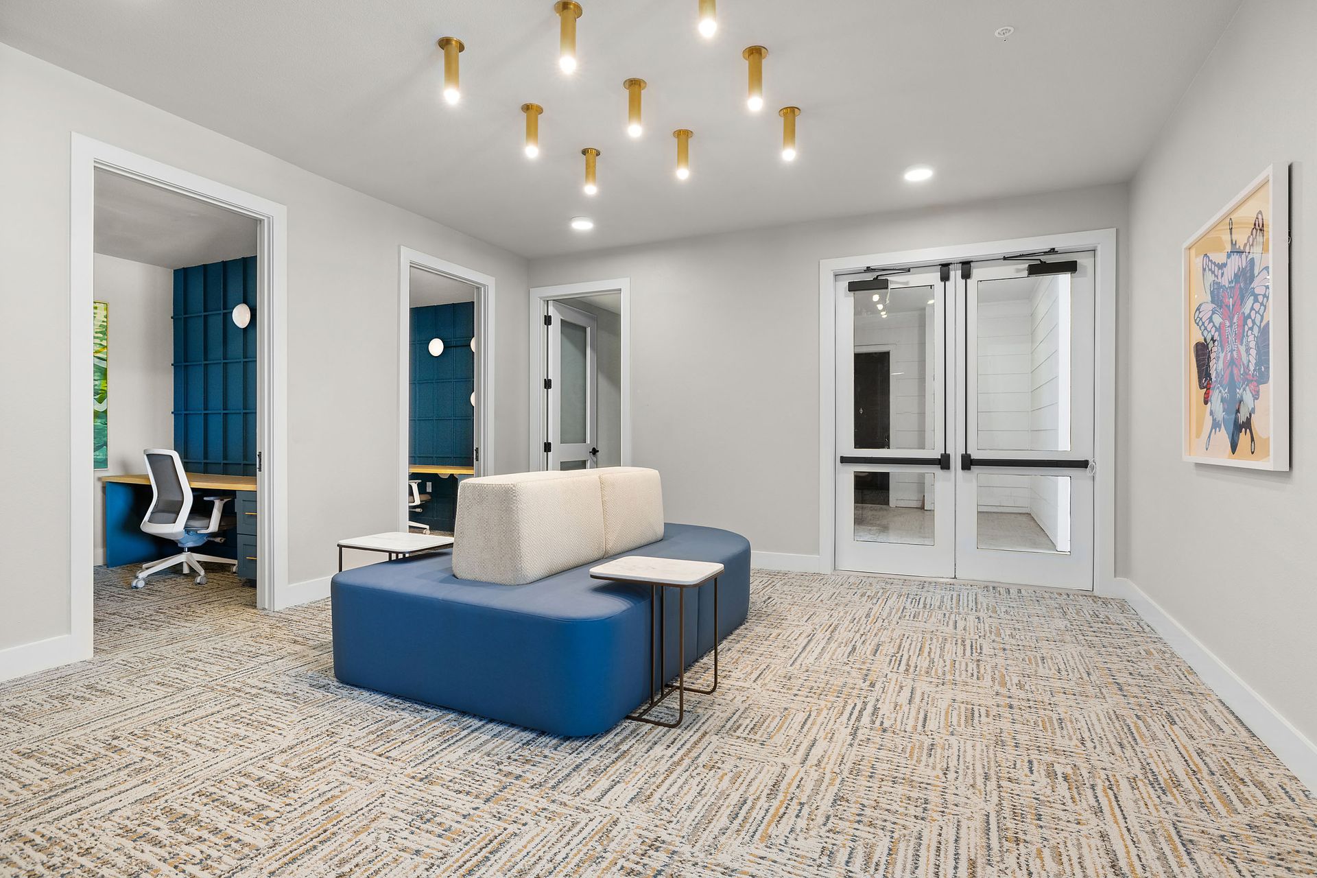 There is a blue couch in the middle of the business center with private work pods for working from home at The Wyatt, offers luxury apartments in North Austin, TX.