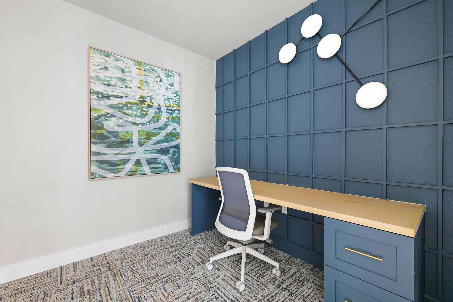 Private work pod with a desk and chair and a painting on the wall at The Wyatt, offers luxury apartments in North Austin, TX.