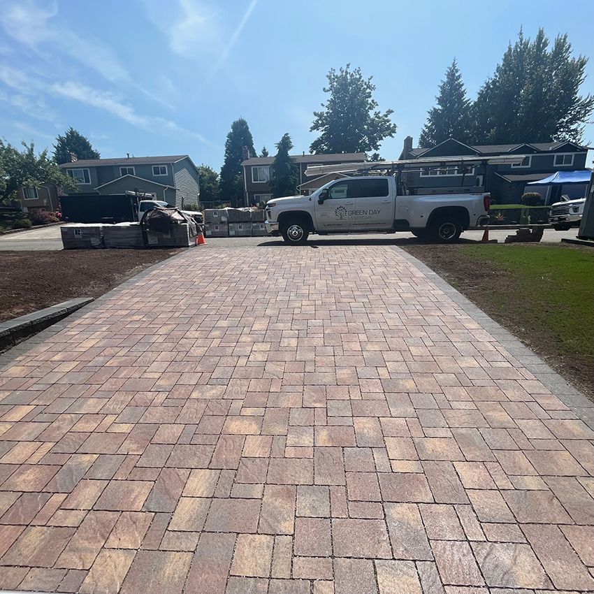 A white truck is parked on a brick driveway