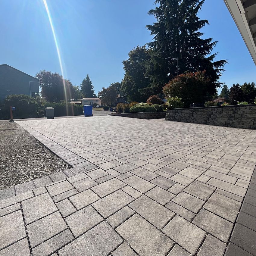 A brick driveway with trees in the background on a sunny day