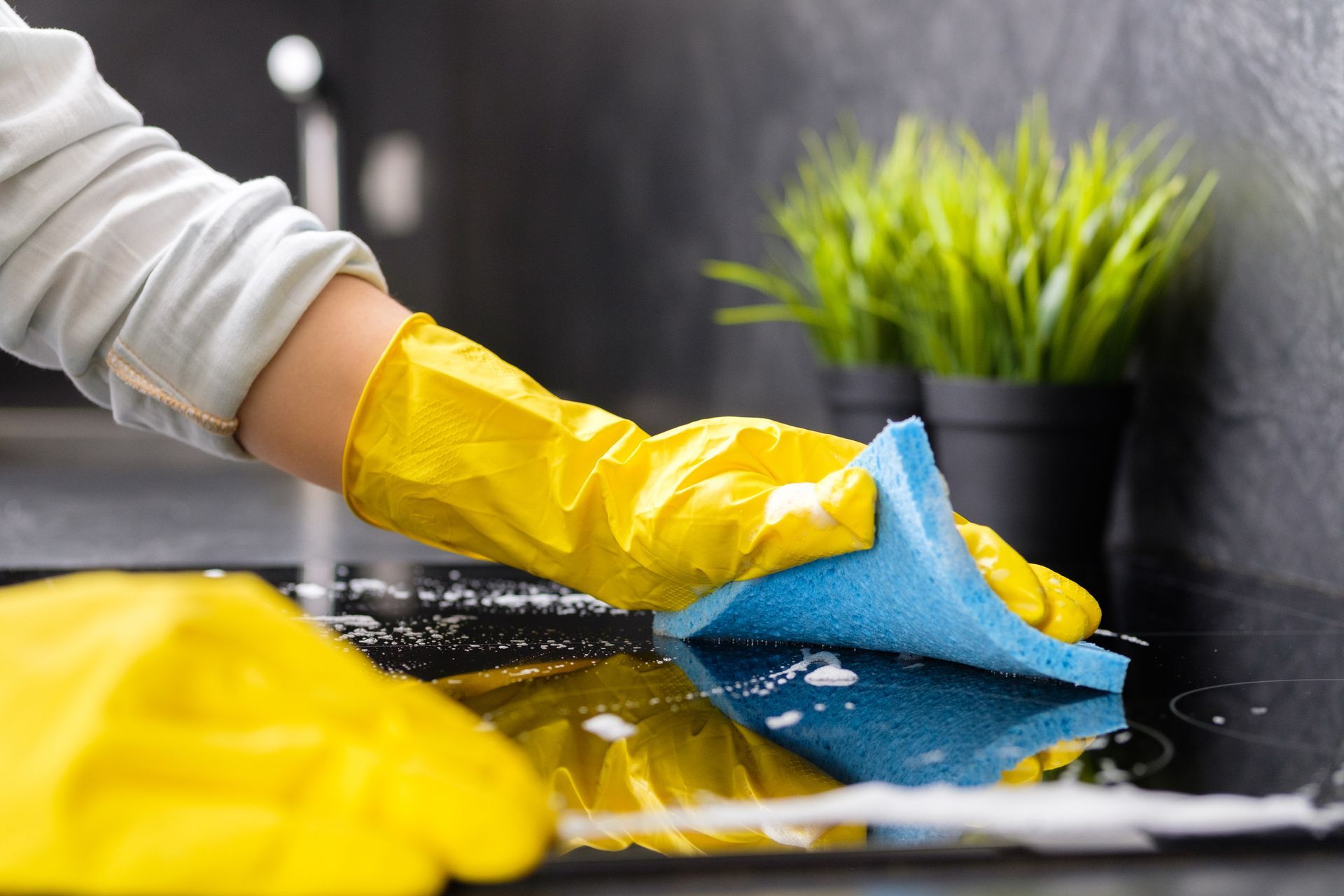 A Person Cleaning With A Blue Sponge — Nassau, NY — Tidy Taskers Cleaning Service
