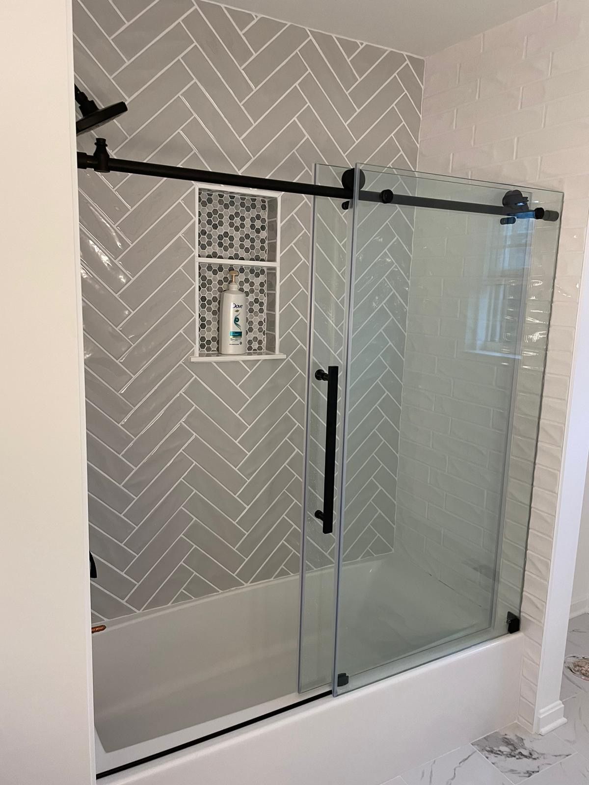 A bathroom with a sliding glass shower door and a bathtub.