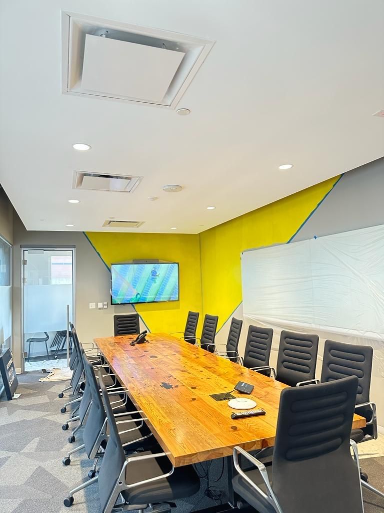 A conference room with a long wooden table and chairs.