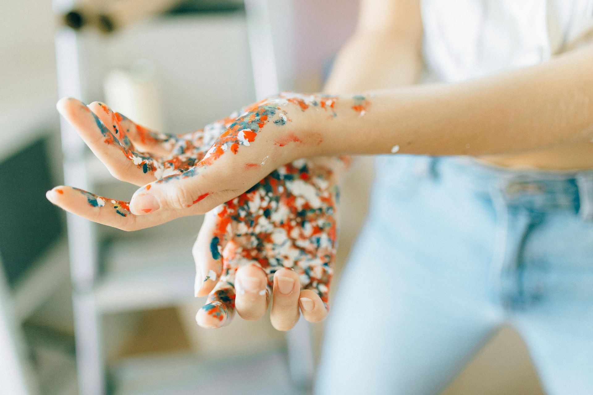 A person is playing with sprinkles in their hands.