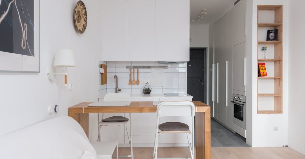 There is a clock on the wall above the table in the kitchen.