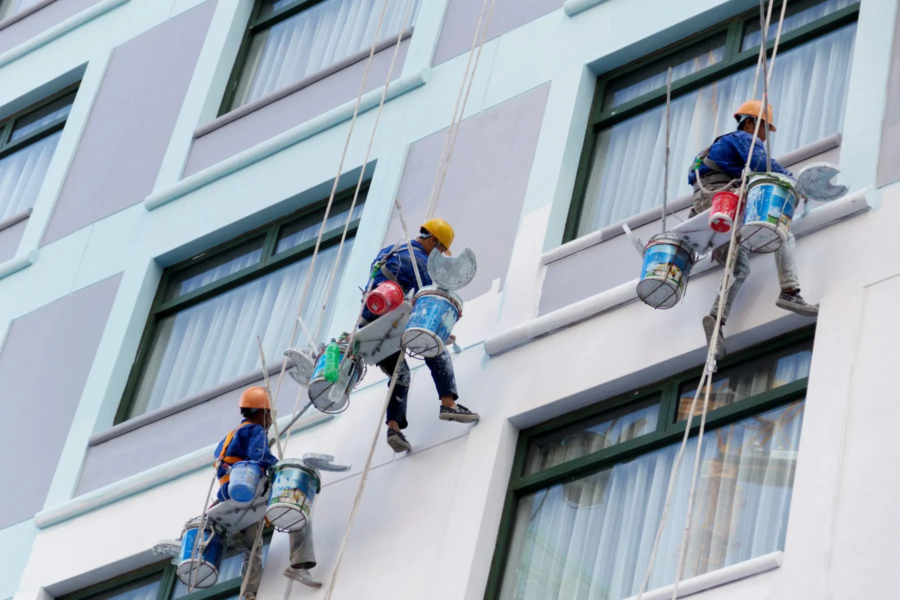 A group of people are painting the side of a building.